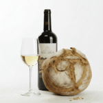 Solaris Bio-Weisswein vom Bio-Weingut Wingert in Nussbaumen (Thurgau) im Glas neben einer Flasche und frisch gebackenem Brot – Schweizer Premiumwein für Genussmomente